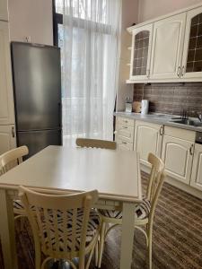 a kitchen with a table and chairs and a refrigerator at Tsar Simeon Veliki in Stara Zagora