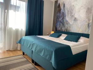 a bedroom with a blue bed with a blue blanket at Apartament Premium 608-593-000 in Białka Tatrzańska