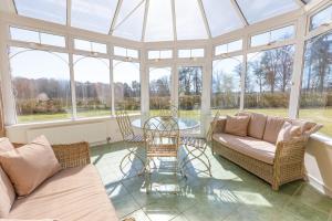 a conservatory with a glass roof with a table and chairs at Dalgheal in Evanton