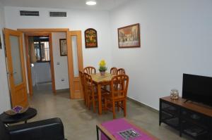 a living room with a table and chairs and a television at Centro in Málaga