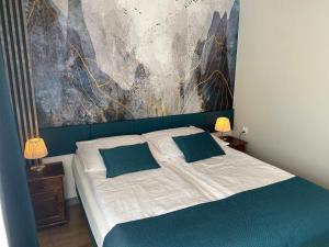 a bedroom with a bed with a painting on the wall at Apartament Premium 608-593-000 in Białka Tatrzańska