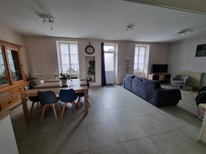 ein Wohnzimmer mit einem Tisch und einem blauen Sofa in der Unterkunft Grande Villa familiale et chaleureuse à Saulieu in Saulieu