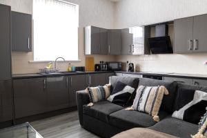 a living room with a couch and a kitchen at Stratford Stay - sleeps up to 9 near City Centre with parking in Birmingham