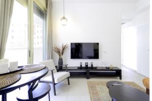 a living room with a table and a tv at Luxury Tel Aviv Seaside by Airsuite in Tel Aviv