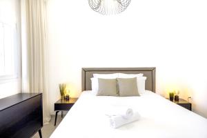 sypialnia z dużym białym łóżkiem z białymi poduszkami w obiekcie Luxury Tel Aviv Seaside by Airsuite w Tel Awiwie