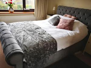 ein Bett mit zwei Kissen darauf in einem Schlafzimmer in der Unterkunft Large 4 double bed house 20 mins from Bath City in Bristol