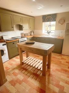 a kitchen with a table in the middle of it at The Hayloft in Gestingthorpe