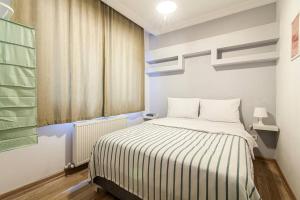 - une chambre avec un lit et une couverture rayée dans l'établissement Sleek Apartment in Balat, Fatih, à Istanbul