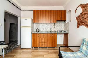 - une cuisine avec des placards en bois et un réfrigérateur dans l'établissement Sleek Apartment in Balat, Fatih, à Istanbul