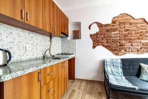une cuisine avec des placards en bois et un mur en briques dans l'établissement Sleek Apartment in Balat, Fatih, à Istanbul
