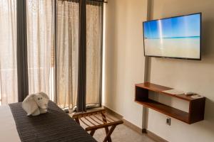 a hotel room with a television and a stuffed elephant on a table at Hotel Muyu Tulum in Tulum
