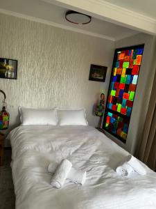 1 dormitorio con 1 cama blanca y 2 toallas en Artist's Cellar, en Telavi