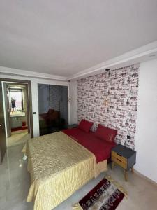 - une chambre avec un grand lit et un mur en briques dans l'établissement Studio propre et calme Casablanca, à Casablanca