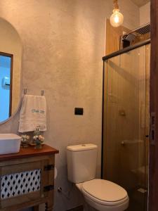 a bathroom with a toilet and a sink and a shower at Chalé Paraíso -Maracajaú 4- Casa 38 - Beira-mar in Maxaranguape