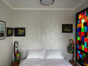 una camera con un letto bianco e alcune immagini sul muro di Artist's Cellar a Telavi