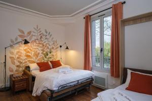 1 Schlafzimmer mit 2 Betten und einem großen Fenster in der Unterkunft Villa Forestière Studio L'Acacia in Quincy-Voisins