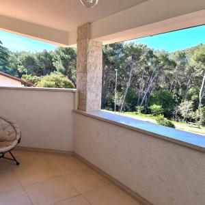 a room with a large window with a view of trees at Apartmani Val in Pula