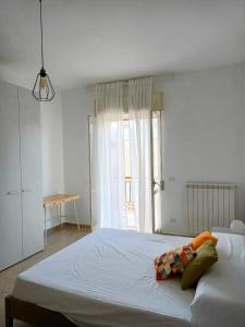 ein weißes Schlafzimmer mit einem großen Bett und einem Fenster in der Unterkunft Casa Teresa in Castellaneta