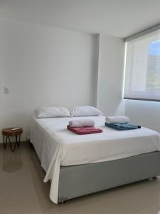 een slaapkamer met een bed met handdoeken erop bij Estadía, hermosos apartasoles en Santafé de Antioquia in Santa Fe de Antioquia