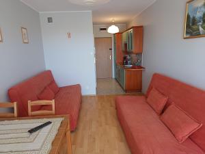sala de estar con sofá rojo y mesa en Studio Krynica, en Krynica Morska