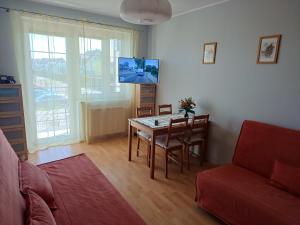 ein Wohnzimmer mit einem Tisch und einem Sofa in der Unterkunft Studio Krynica in Krynica Morska