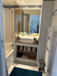 uma casa de banho com um lavatório, uma banheira e um espelho. em Vue mer et sur la baie de Cannes piscine 450m2 randonnée VTT au pied de l Esterel em Théoule-sur-Mer