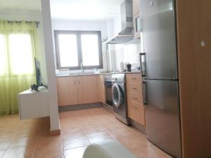 a kitchen with a stainless steel refrigerator and a dishwasher at Casa Calderetas in San Bartolomé