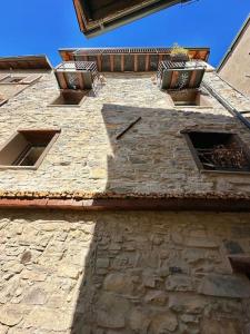 an old stone building with three windows on it at Romantic home with beautiful view lake of Como and Villa Oleandra in Laglio