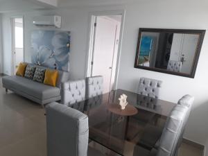 sala de estar con sofá, mesa y espejo en 2P1-AL3 APARTAMENTO DE 2 ALCOBAS FRENTE AL MAR CON AIRE ACONDICIONADO Y WIFI, en Cartagena de Indias