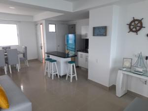 cocina con encimera y taburetes en una habitación en 2P1-AL3 APARTAMENTO DE 2 ALCOBAS FRENTE AL MAR CON AIRE ACONDICIONADO Y WIFI, en Cartagena de Indias