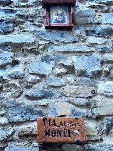 un cartel en una pared de piedra con una ventana y una estatua en Romantic home with beautiful view lake of Como and Villa Oleandra, en Laglio