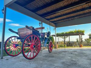 an old red carriage parked under a building at Casa De Linda in Antimácheia +25 photos