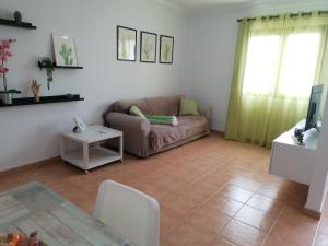 ein Wohnzimmer mit einem Sofa und einem Tisch in der Unterkunft Casa Calderetas in San Bartolomé