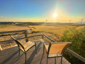 a deck with two chairs and a cat sitting on it at Casa De Linda in Antimácheia