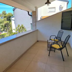 a balcony with two chairs and a table at Apartmani Val in Pula