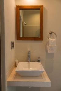 lavabo blanco en el baño con espejo en Hotel Muyu Tulum en Tulum