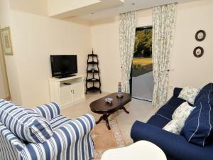a living room with two couches and a tv at Dafni (2 bedrooms, sleeps 4) in Sami
