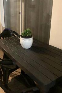 una planta en una olla blanca sentada en una mesa de madera en Intero appartamento Milano, en Bollate