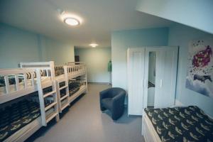 a bedroom with two bunk beds and a chair at Hostel Browar Jedlinka in Jedlina-Zdrój