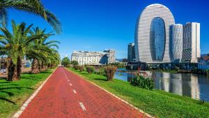 a red brick path next to a river with buildings at Apartment Katya in Batumi