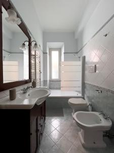 ein Badezimmer mit zwei Waschbecken, einem WC und einem Spiegel in der Unterkunft Nea apartment in Rom
