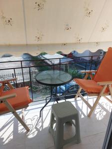 a table and chairs on a balcony with a view at Theos Apartment in Kanallákion