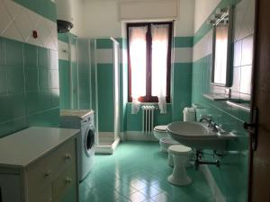 a green bathroom with a sink and a washing machine at APPARTAMENTO NEL CENTRO DI SANTA TERESA GALLURA in Santa Teresa Gallura