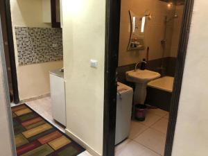 La salle de bains est pourvue d'un lavabo et de toilettes. dans l'établissement احجزلى, à Ville du 6 Octobre