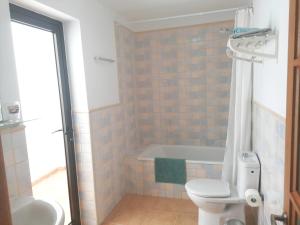 a bathroom with a toilet and a bath tub at Casa Calderetas in San Bartolomé