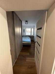 pasillo que conduce a un dormitorio con cama en Apartament Centroom, en Olsztyn