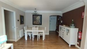 a dining room with a white table and chairs at Amplio Apto con patio privado in Aranjuez