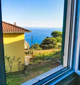 uma janela com vista para o oceano a partir de uma casa em CodeminCampiglia Casa Vista Mare con Giardino em Campiglia
