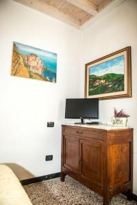 um quarto com uma cama e uma secretária com uma televisão em CodeminCampiglia Casa Vista Mare con Giardino em Campiglia