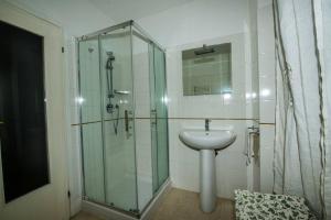 uma casa de banho com uma cabina de duche em vidro e um lavatório. em CodeminCampiglia Casa Vista Mare con Giardino em Campiglia